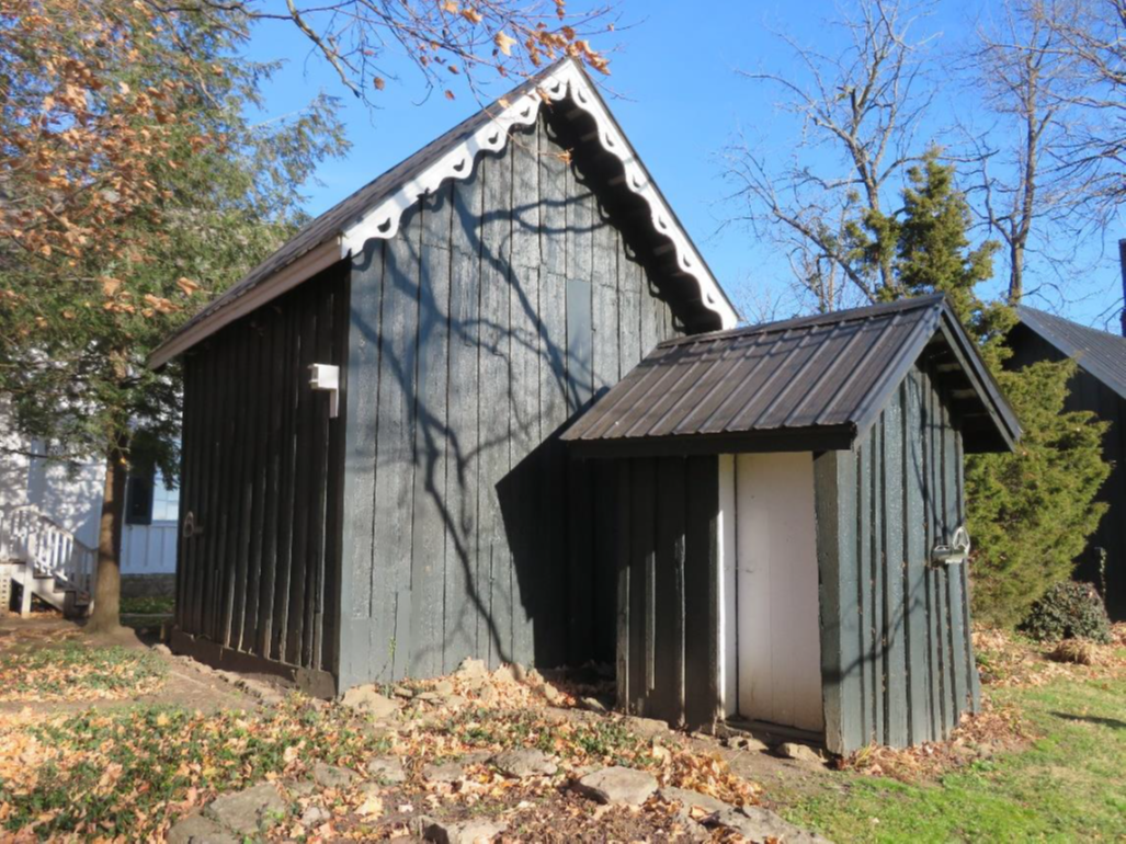 Southwest and southeast (rear) elevations of the smokehouse (to the left), as well as the façade and southeast elevation of the 